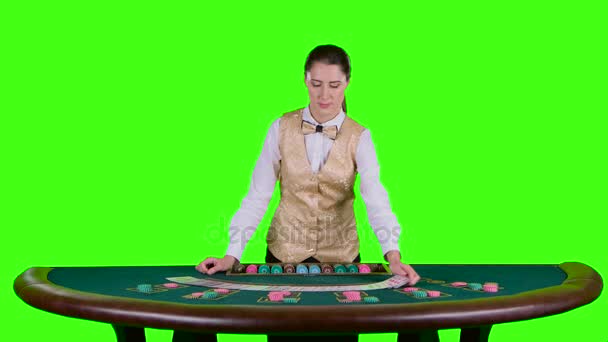 Casinò croupier femminile in piedi al tavolo distribuisce le carte sotto forma di un arco sul tavolo da poker. Schermo verde. Rallentatore — Video Stock