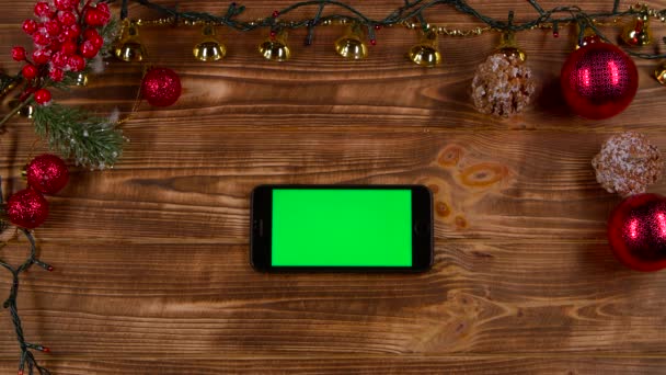 Smartphone van az asztalon, mellett az új év fények. Szemközti nézet — Stock videók