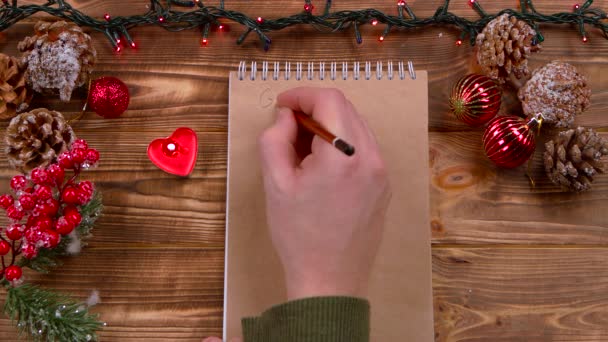 Mans mano escribe un mensaje de Año Nuevo a Santa Claus. Vista superior — Vídeos de Stock
