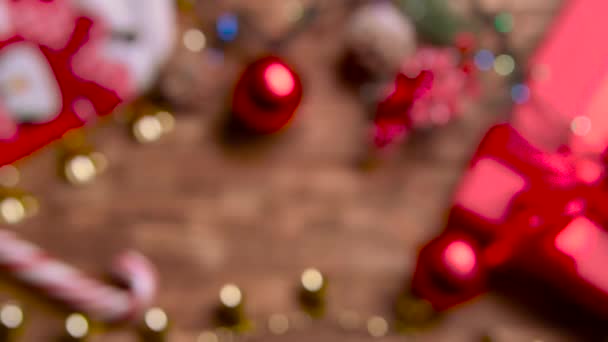 Különböző új év játékok desszerttel és virágokkal fekszenek az asztalon. Szemközti nézet — Stock videók