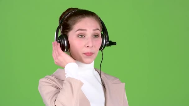 Pracovník podpory hovoří zákazníkům na sluchátkách. Zelená obrazovka — Stock video