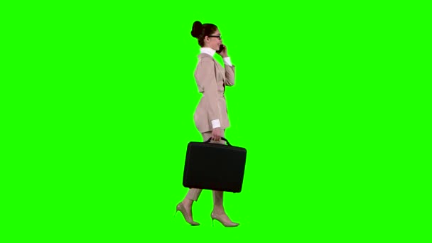 Business κυρία με περιπτώσεις στα χέρια μιλάει στο τηλέφωνο. Πράσινη οθόνη. Πλάγια όψη — Αρχείο Βίντεο