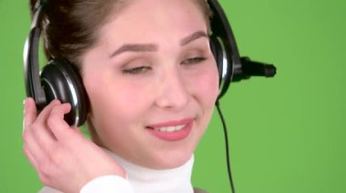 Destek işçi müşteriler için kulaklýklý mikrofon üzerinde konuşuyor. Yeşil ekran. Yakın çekim