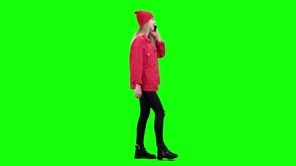 Teenage stylish girl is walking down the street and talking on the phone. Green screen. Side view — Stock Video