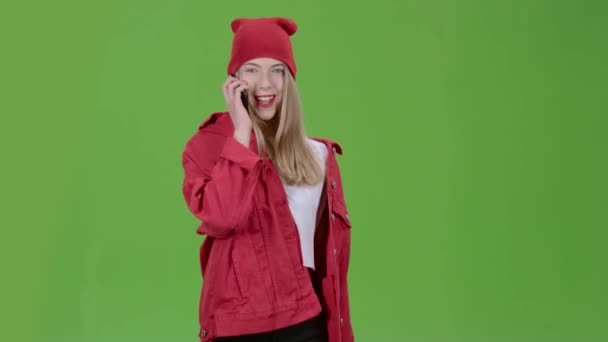 Teenage stylish girl is walking down the street and talking on the phone. Green screen — Stock Video