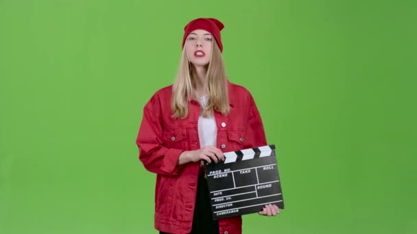 Asszisztens üzemeltető nem a pamut clapperboard, és a levelek. Zöld képernyő — Stock videók