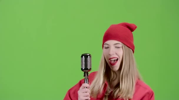 Fille en vêtements élégants chante dans un microphone rétro chansons à succès. Écran vert — Video