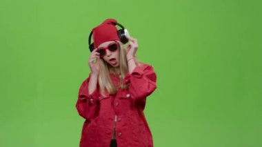 Kız enerjik şarkıları ile kulaklıklar müzik dinler. Yeşil ekran