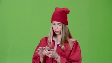 Kız telefonu resimlerde bakar ve baş parmak işareti gösterir. Yeşil ekran