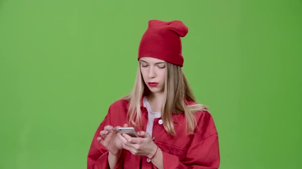 Meisje kijkt naar de foto's in de telefoon en toont een thumbs up. Groen scherm — Stockvideo