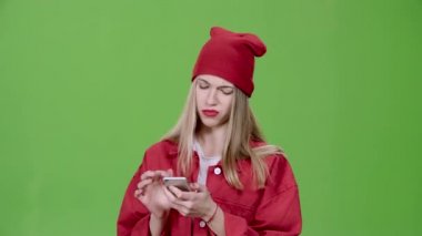 Kız telefonu resimlerde bakar ve baş parmak işareti gösterir. Yeşil ekran. Ağır çekim