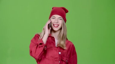 Kız üstünde belgili tanımlık telefon ve gülümsüyor konuşuyor. Yeşil ekran. Ağır çekim