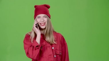Kız üstünde belgili tanımlık telefon ve gülümsüyor konuşuyor. Yeşil ekran. Ağır çekim
