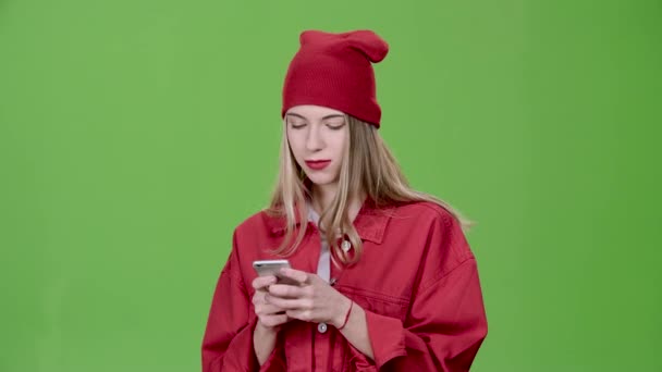 Tiener wordt een bericht afgedrukt op de telefoon. Groen scherm. Slow motion — Stockvideo