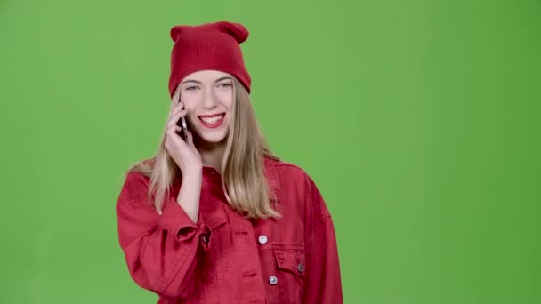 Dívka mluví o telefonu a úsměvy. Zelená obrazovka. Zpomalený pohyb — Stock video