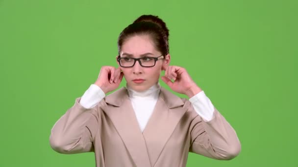 Girl closes her ears from a sharp noise. Green screen. Slow motion — Stock Video