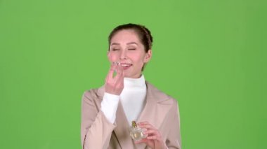 Satıcı kozmetik hoş bir koku parfüm tanıtır. Yeşil ekran. Ağır çekim