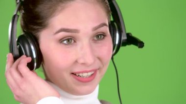 Destek işçi müşteriler için kulaklýklý mikrofon üzerinde konuşuyor. Yeşil ekran. Yakın çekim. Ağır çekim