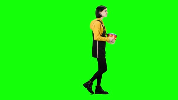 Kız onun elinde patlamış mısır ile film izlemek için gidiyor. Yeşil ekran. Yan görünüm — Stok video