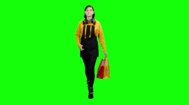 Teen alışveriş sonra paketleri ile gider ve etrafına bakıyor. Yeşil ekran
