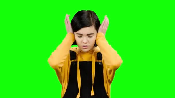 Dívka uzavře si uši rukama. Zelená obrazovka — Stock video
