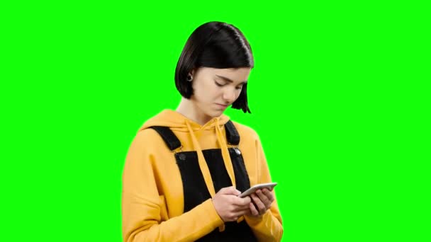 Meisje kijkt naar de telefoon en vreemde foto's ziet. Groen scherm — Stockvideo