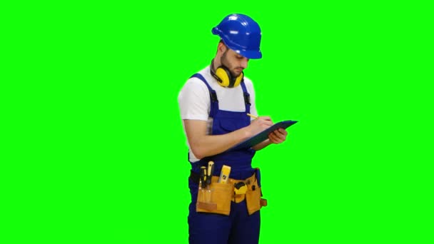 Foreman escreve medidas em um tablet de papel e sorri. Tela verde — Vídeo de Stock