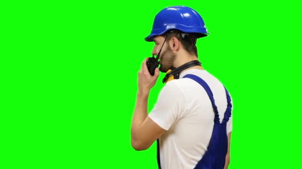 Constructor habla en un walkie talkie a los colegas. Pantalla verde — Vídeos de Stock