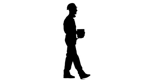 Builder carries in his hands three bricks. White background. Silhouette. Side view — Stock Video