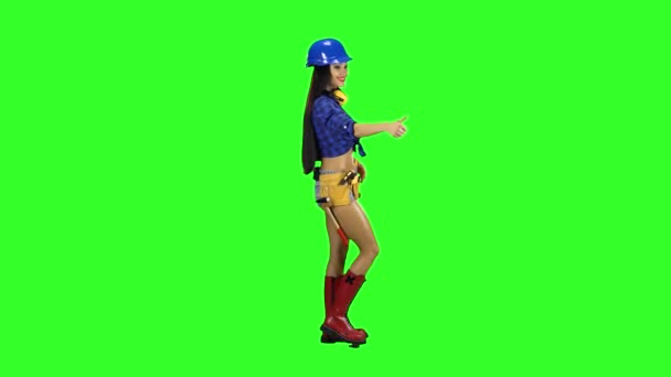 Menina usando capacete e botas vai para o lado em um fundo verde — Vídeo de Stock