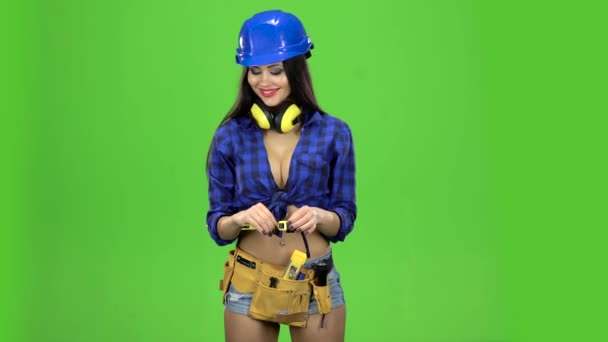Brunette dívka drží usmívající se páska segment na zeleném pozadí — Stock video