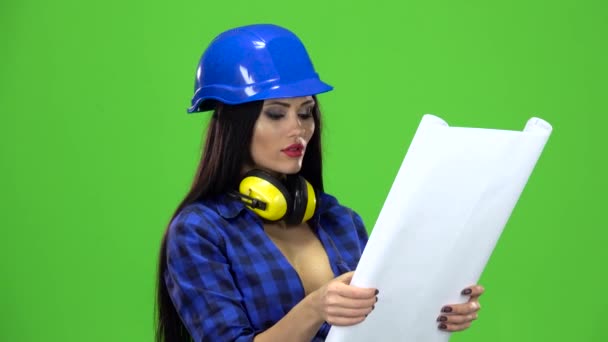 Woman in the blue plaid shirt with a drawing in the hands of smiling on green background — Stock Video