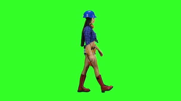 Девушка в шлеме и шортах идет боком на зеленом фоне — стоковое видео