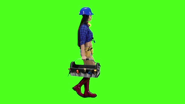 Κορίτσι με το κράνος και το πουκάμισο πηγαίνει προς τα πλάγια σε πράσινο φόντο. Αργή κίνηση — Αρχείο Βίντεο