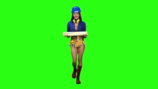 Meisje in korte broek blauw helm met de planken wandelingen op een groene achtergrond. Slow motion — Stockvideo