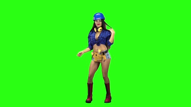 Vooraanzicht van meisje dragen helm en shorts erotisch dansen op groene achtergrond. Slow motion — Stockvideo