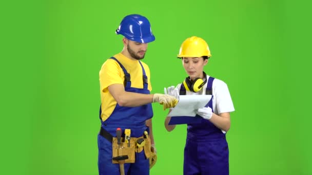 Designer flicka visar en skiss av en byggnad till en byggmästare. Grön skärm — Stockvideo