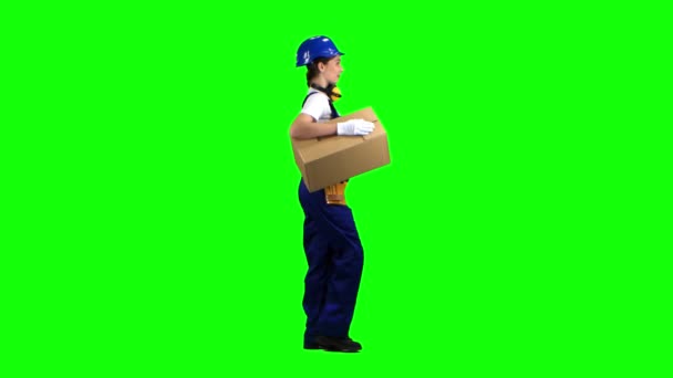 Fille constructeur porte une boîte en carton. Écran vert. Vue latérale — Video