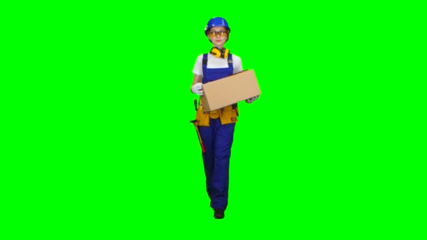 Девушка-строитель в очках носит картонную коробку. Зеленый экран — стоковое видео