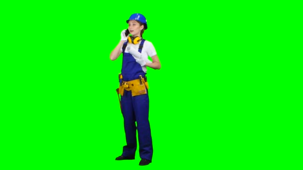 Architect is standing and talking on the phone with a drawing in her hands. Green screen — Stock Video