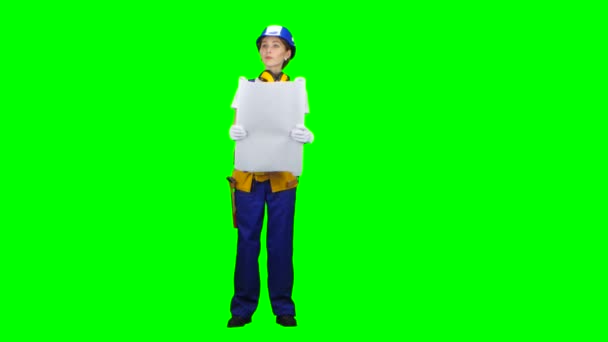 Girl in a helmet and a drawing in her hands is standing and looking into the distance. Green screen — Stock Video