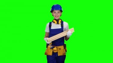 İnşaat işçisi kask giyen üç ahşap Komiteler taşır. Yeşil ekran