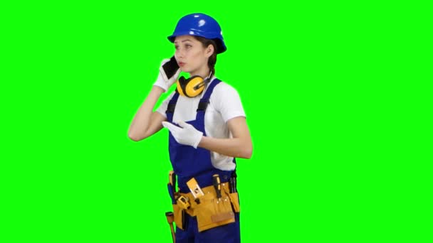 Engineer is standing and talking on the phone with a drawing in her hands. Green screen — Stock Video