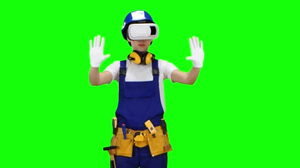 Builder girl in virtual reality glasses plays an interesting game. Green screen — Stock Video