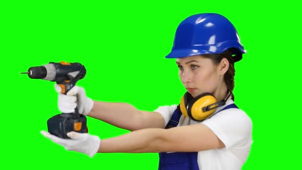 Bauarbeiterin hält eine Bohrmaschine in der Hand und schaut sich um. Green Screen. Nahaufnahme — Stockvideo