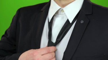 Mans el altında boynuna kravat sıkılaştırır. Yeşil ekran. Yakın çekim
