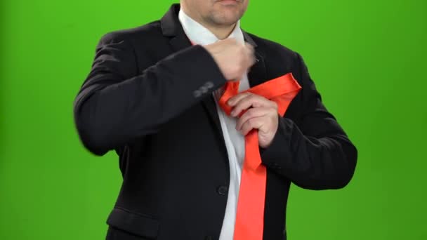 Человек завязывает красный галстук. Зеленый экран. Закрыть — стоковое видео