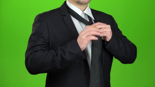 Man ties up a black tie. Green screen. Close up — Stock Video