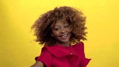 Mulattus kameraya gülümsüyor. Sarı arka plan. Ağır çekim