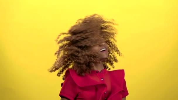 Αφρικανική αμερικανική κάνει μαλλιά μύγες. Κίτρινο φόντο. Αργή κίνηση — Αρχείο Βίντεο